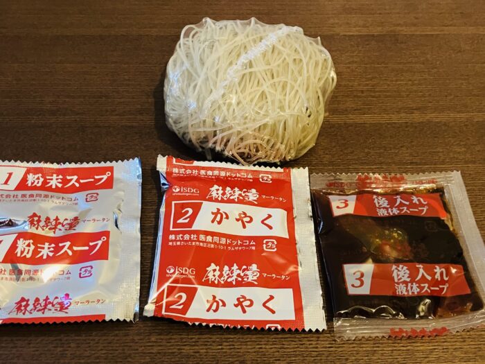 春雨、粉末スープ、かやく、液体スープをカップから取り出し、カップに春雨を入れる